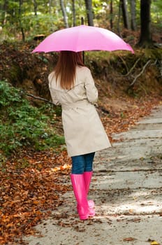 Young woman with umbrella walking through the park