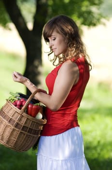 Young woman with basket filled fresh vegetables