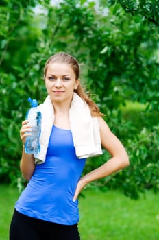 Smiling woman with water bottle after workout