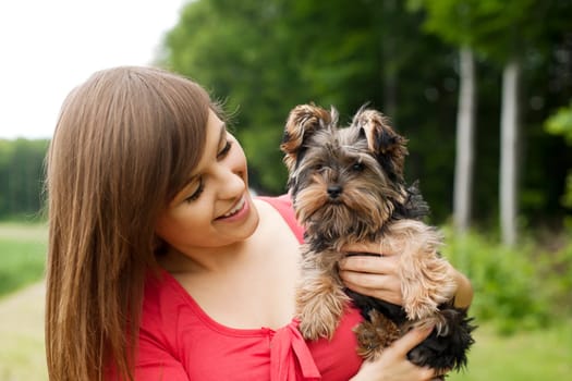 Smiling woman holding cute puppy