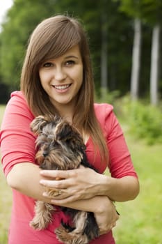 Smiling woman holding cute puppy