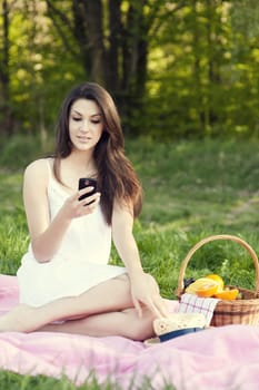 Young woman texting on meadow