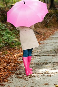 Young woman with umbrella walking through the park