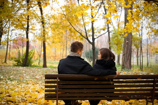 Young couple sitting on bench in park