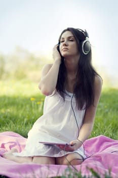 Young woman listening to music on meadow