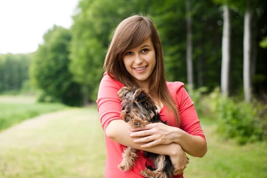Smiling woman holding cute puppy