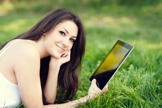Young woman using digital tablet on meadow