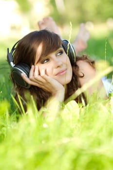 Young woman listening music on grass