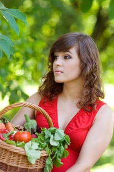 Young woman holding basket filled vegetables