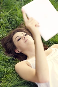 Young woman using digital tablet on meadow
