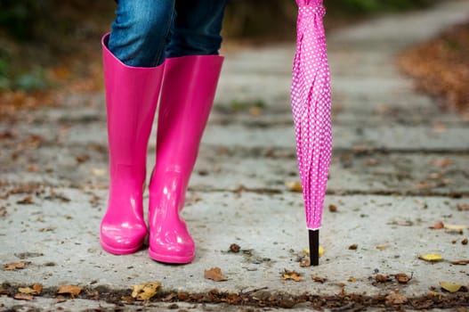 Woman with umbrella wearing rubber boots