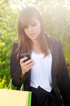 Young woman reading a text message while at the shopping