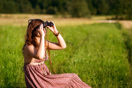 Young woman looking through binoculars