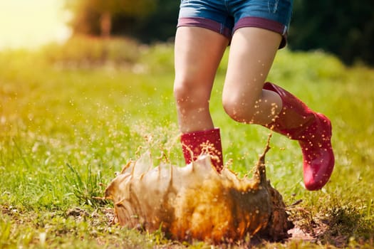 Woman have fun jumping in puddle
