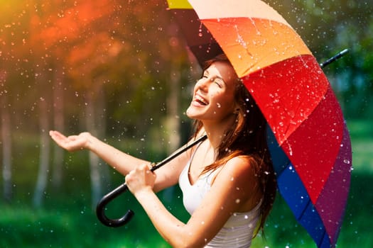 Laughing woman with umbrella checking for rain