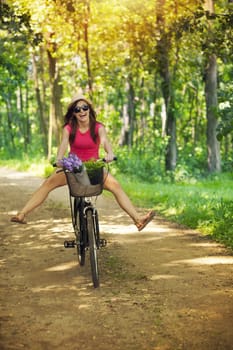 Happy woman enjoying a cycle ride in forest