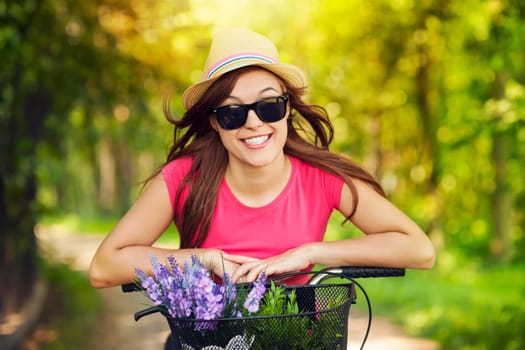 Portrait of smiling woman riding bicycle in park