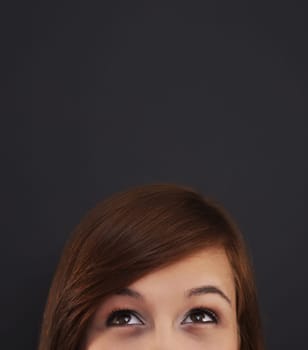 Young woman looking up at blackboard