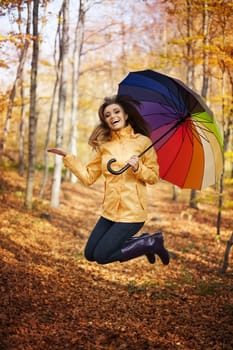 Young woman jumping during the rainy day at autumn