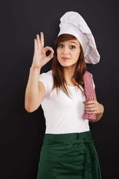 Young female cooking chef showing OK sign