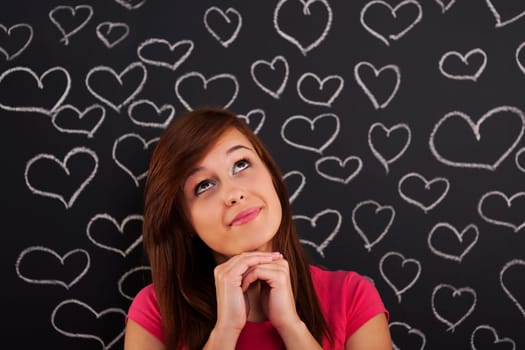 Woman looking up lovingly with hearts drawn on blackboard