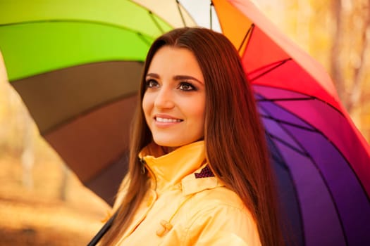 Smiling woman standing under the umbrella