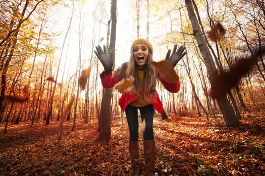 Young woman have fun with autumn leaves