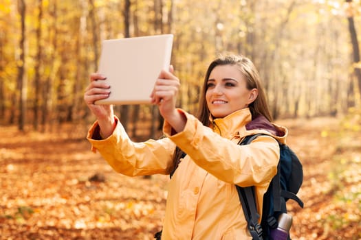 Beautiful woman taking photo by digital tablet