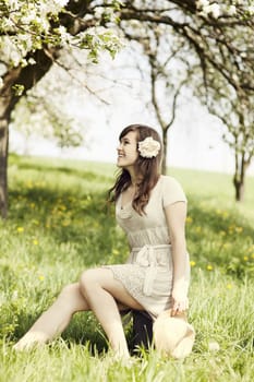 Beautiful girl sitting on suitcase at outdoors
