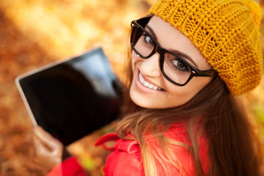 Smiling young woman using digital tablet