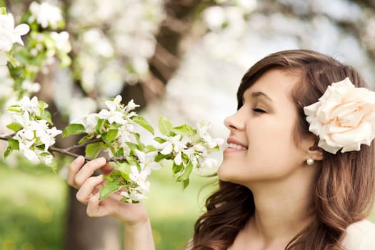 Happy young woman enjoying the fragrance of flowers