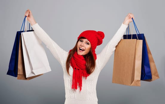 Excited woman holding a lot of shopping bag