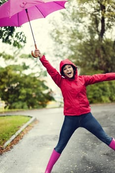 Cute young woman jumping with umbrella