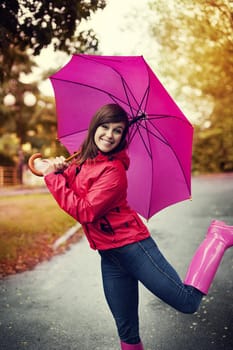 Happy woman with pink umbrella and rubber boots