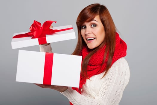 Happy young woman opening christmas gift