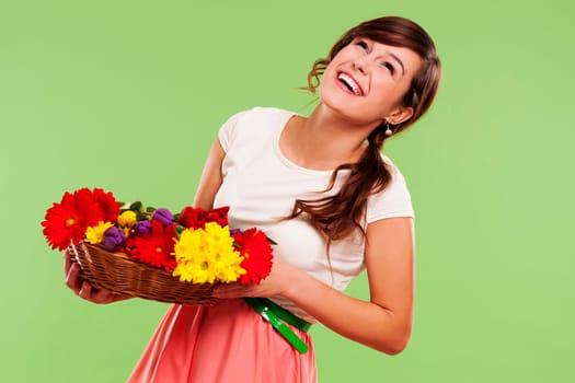 Happy woman in a basket of spring flowers