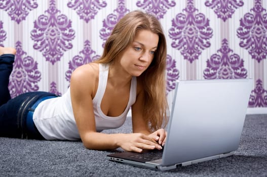 Young woman using laptop on the floor