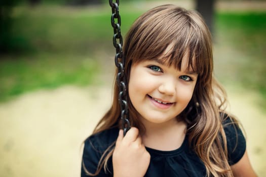 Portrait of smiling girl on swing