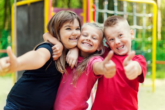 Happy children showing ok sign on playground