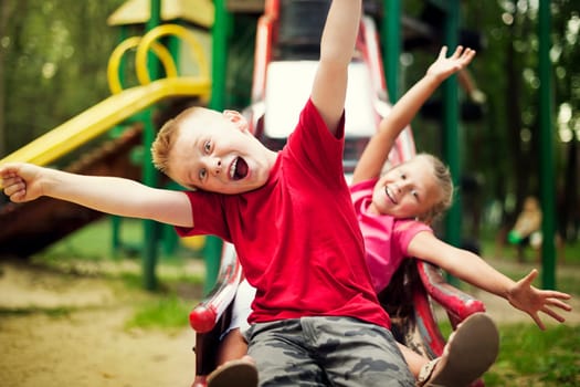 Two kids slide on playground