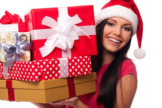 Woman wearing santa hat holding stack of christmas gifts