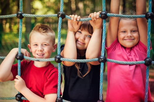 Happy children holding a net on playground