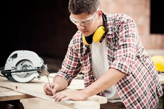Carpenter measuring a wooden plank
