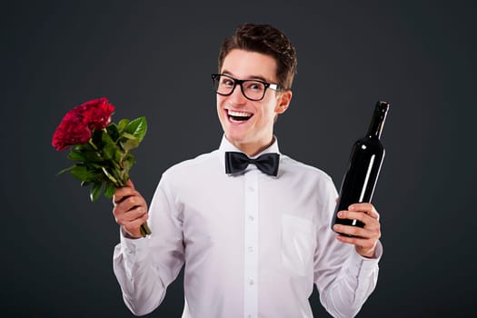Happy man with a bouquet of roses and wine