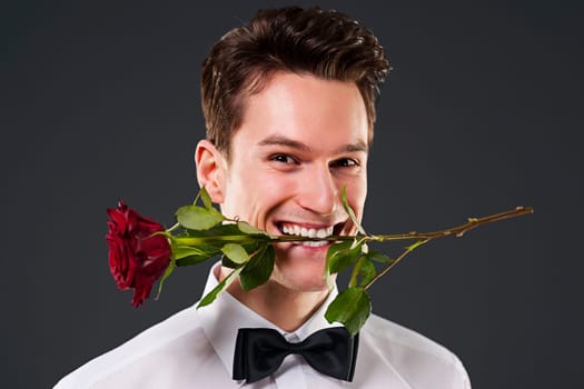 Man with a red rose in mouth