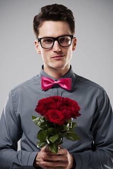 Smiling man holding red roses
