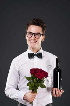 Handsome man with red wine and bouquet of roses