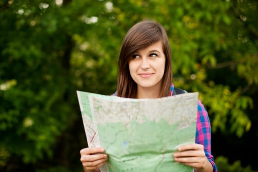 Beautiful young woman holding a map