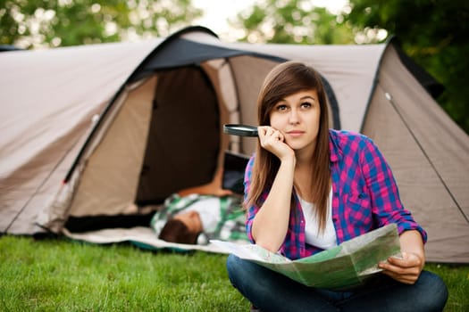 Beautiful young woman sitting in front of tent