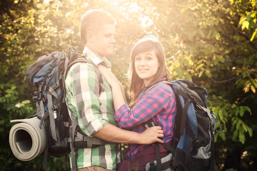 Loving couple in forest at sunset